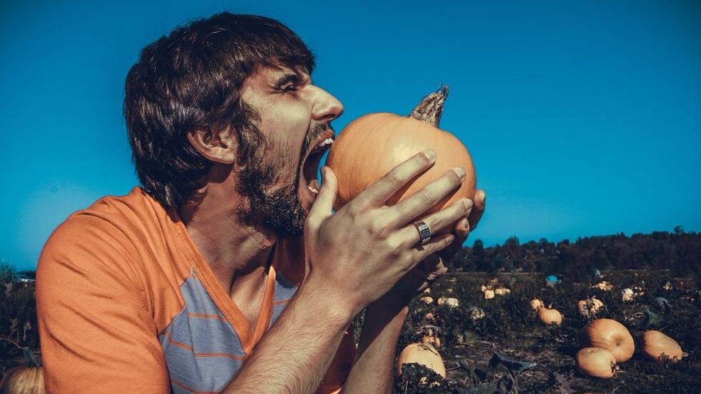 Un uomo mangia la zucca per aumentare la sua potenza